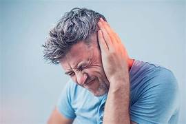 Man with hand to ear, experiencing tinnitus